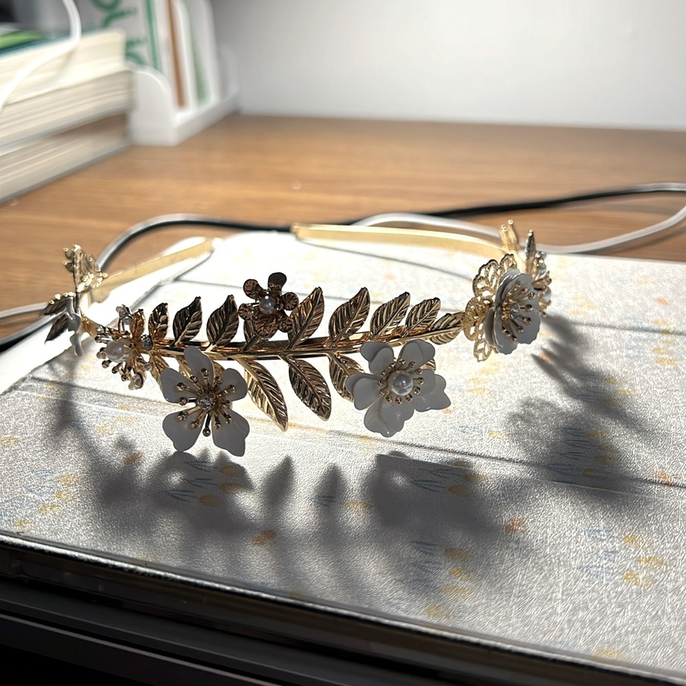 gold metal headband decorated with white flowers and leaves